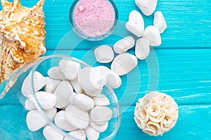 Sea Ã¢â¬â¹Ã¢â¬â¹salt in a glass white stones and Shell for spa and relaxation on a blue background